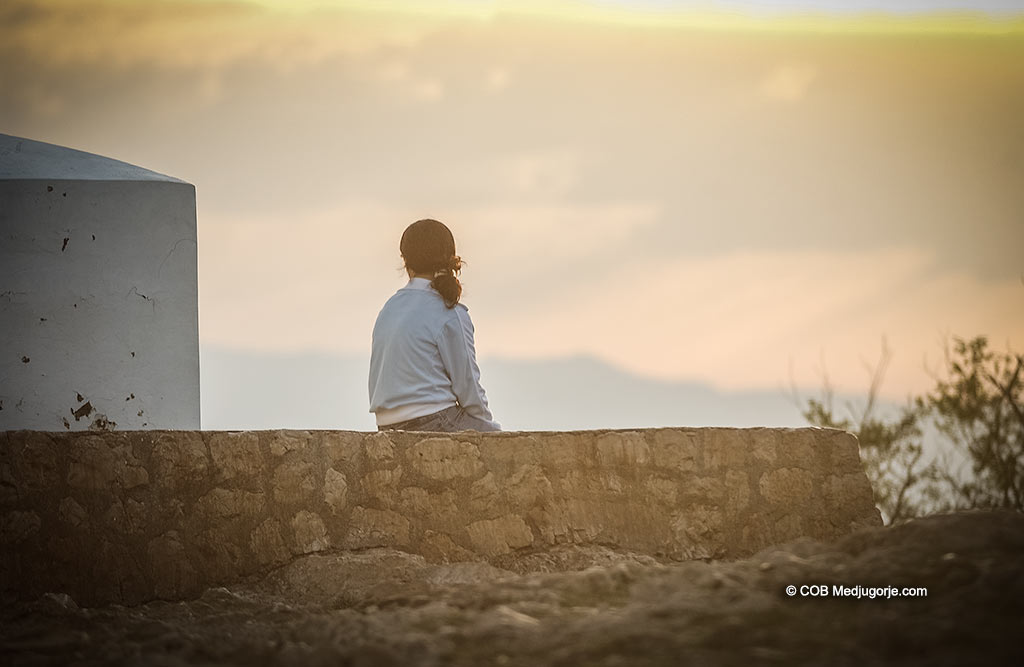 Lone pilgrim praying on Cross Mountain in Medjugorje