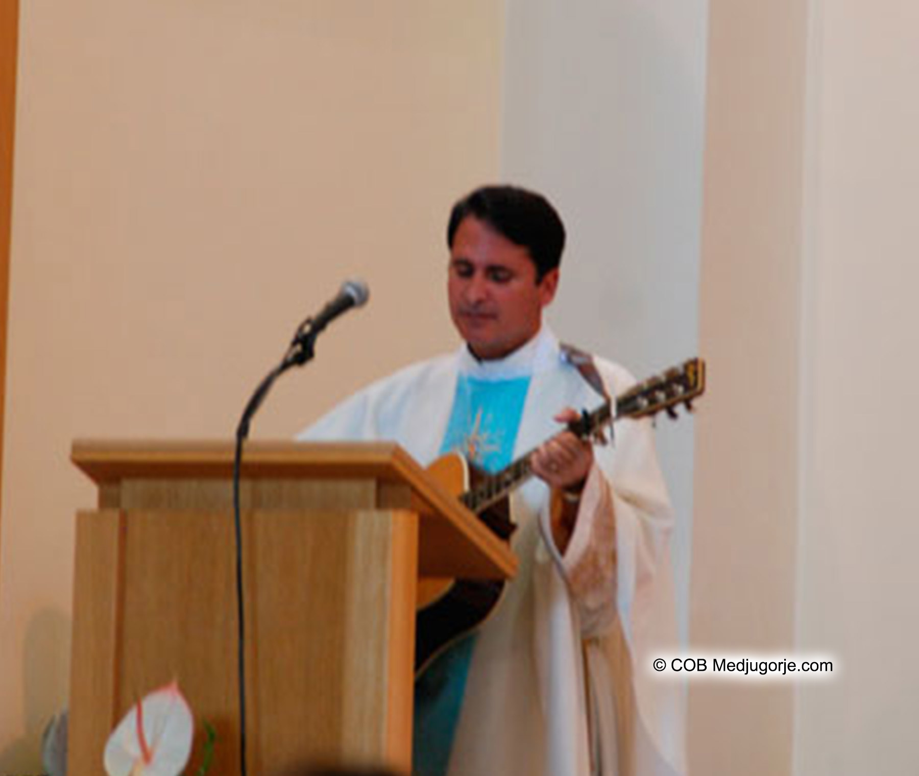 Fr. Mangano with the guitar in his hands in Medjugorje at St. James Church