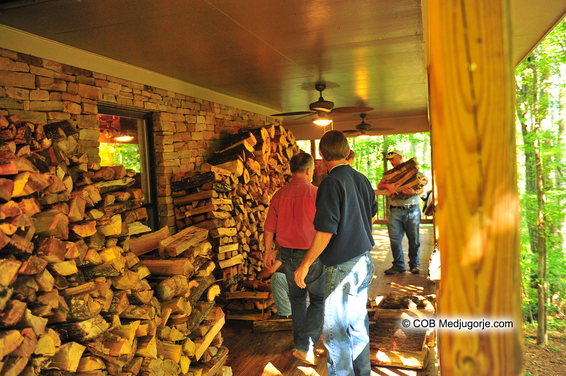 Community of Caritas stacking firewood