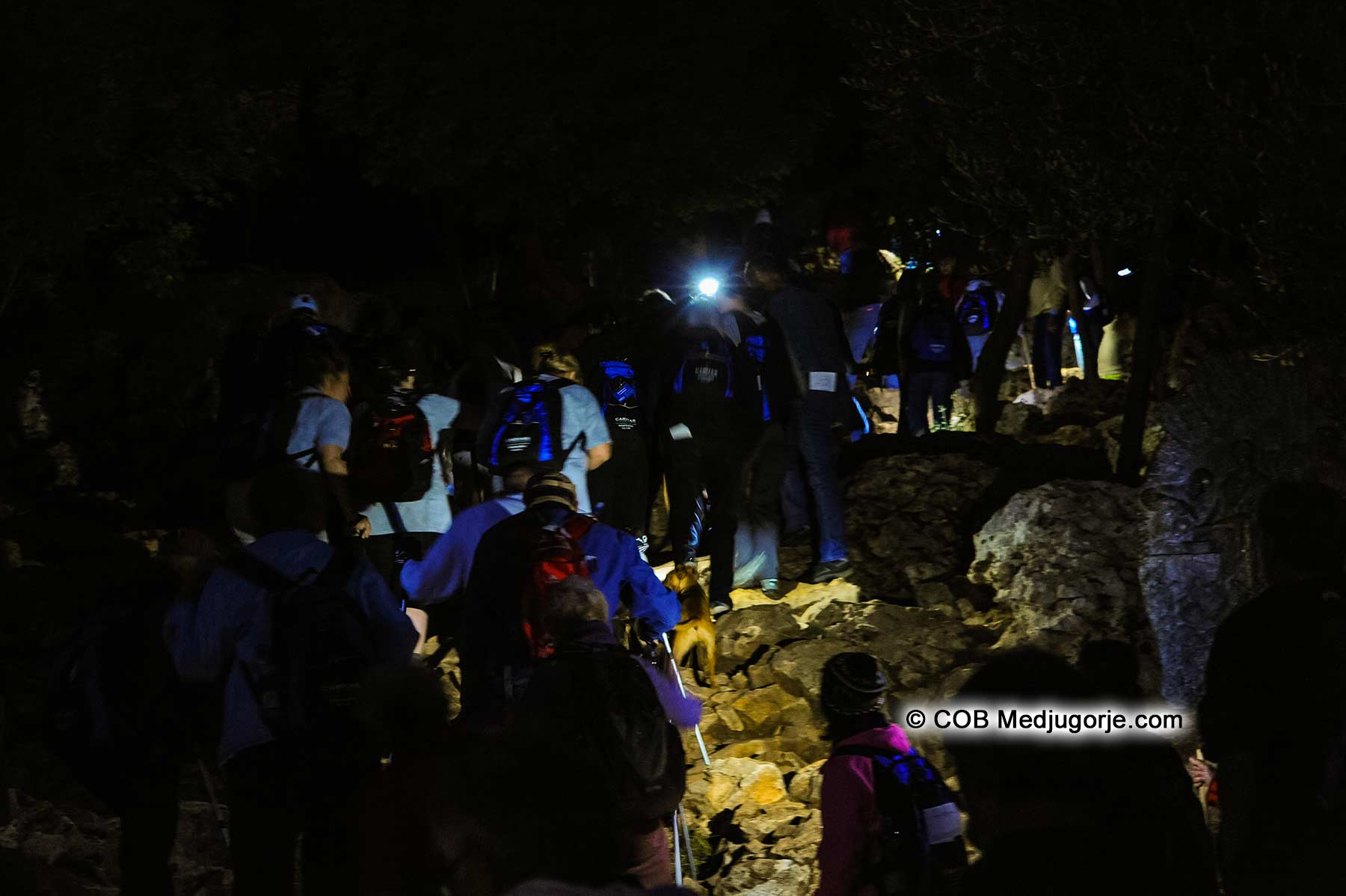 Pilgrims climbing Cross Mountain in the early morning hours