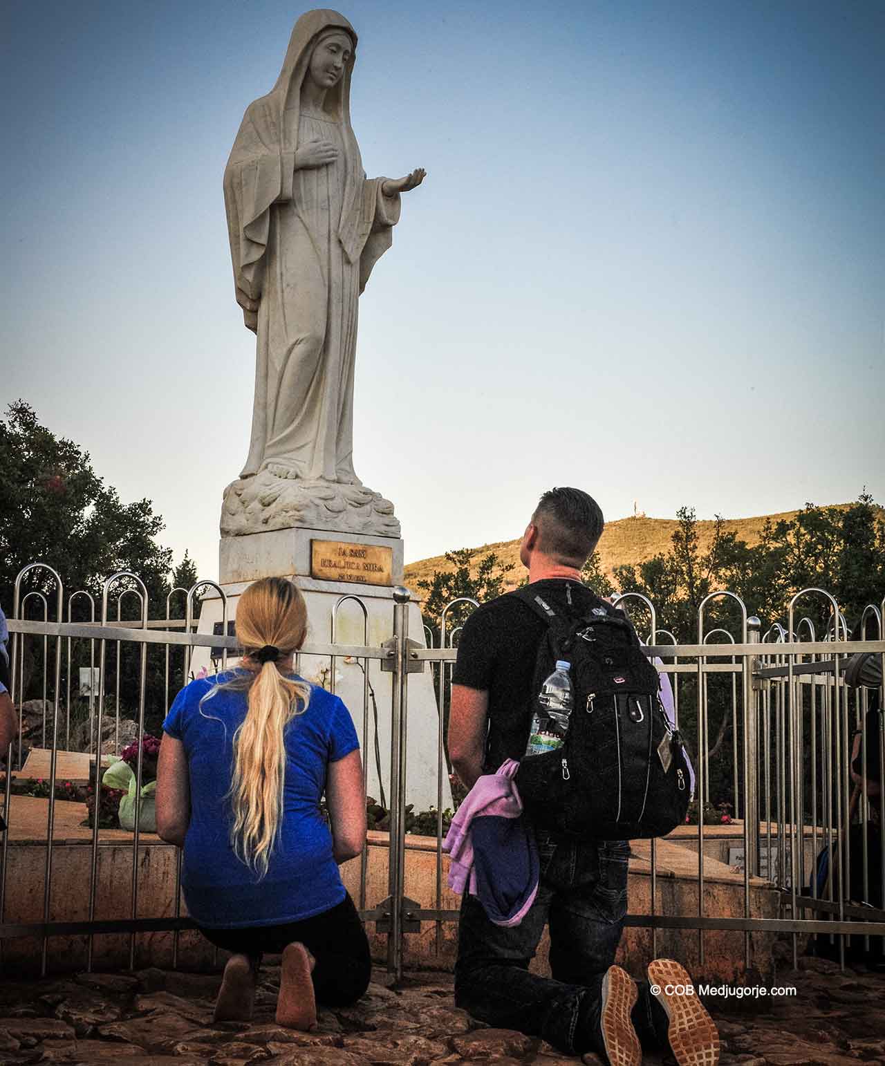 A Family praying on Apparition Mountain in Medjugorje, July 2018