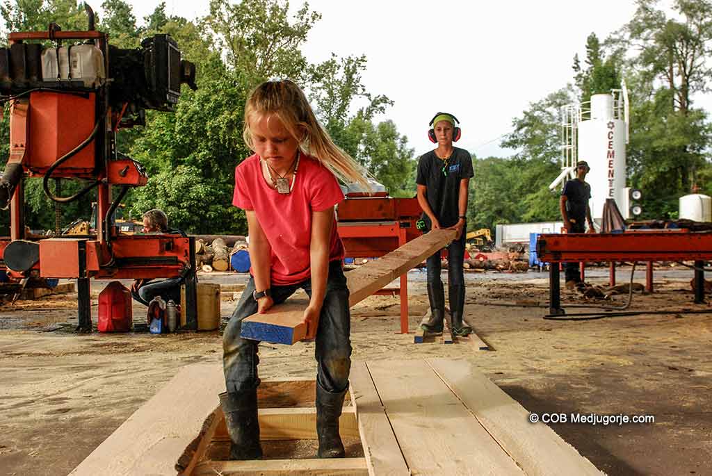 Caritas Community kids stacking lumber