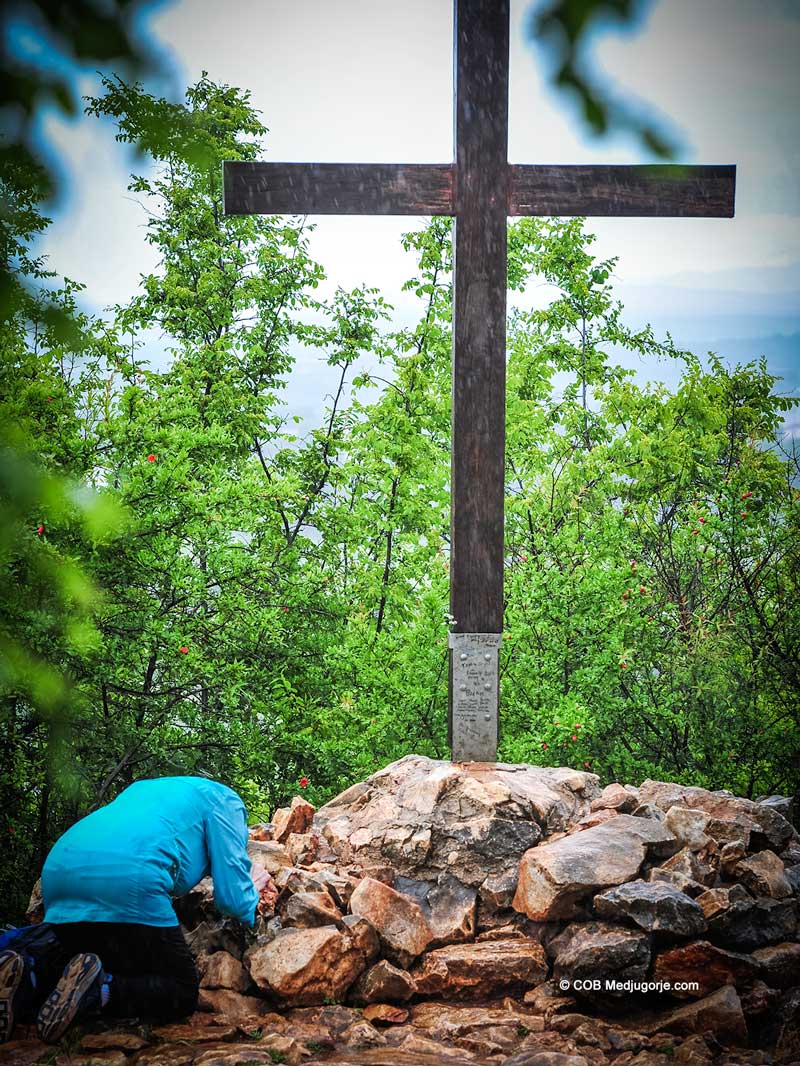 Pilgrim praying on Apparition Mountain in Medjugorje.