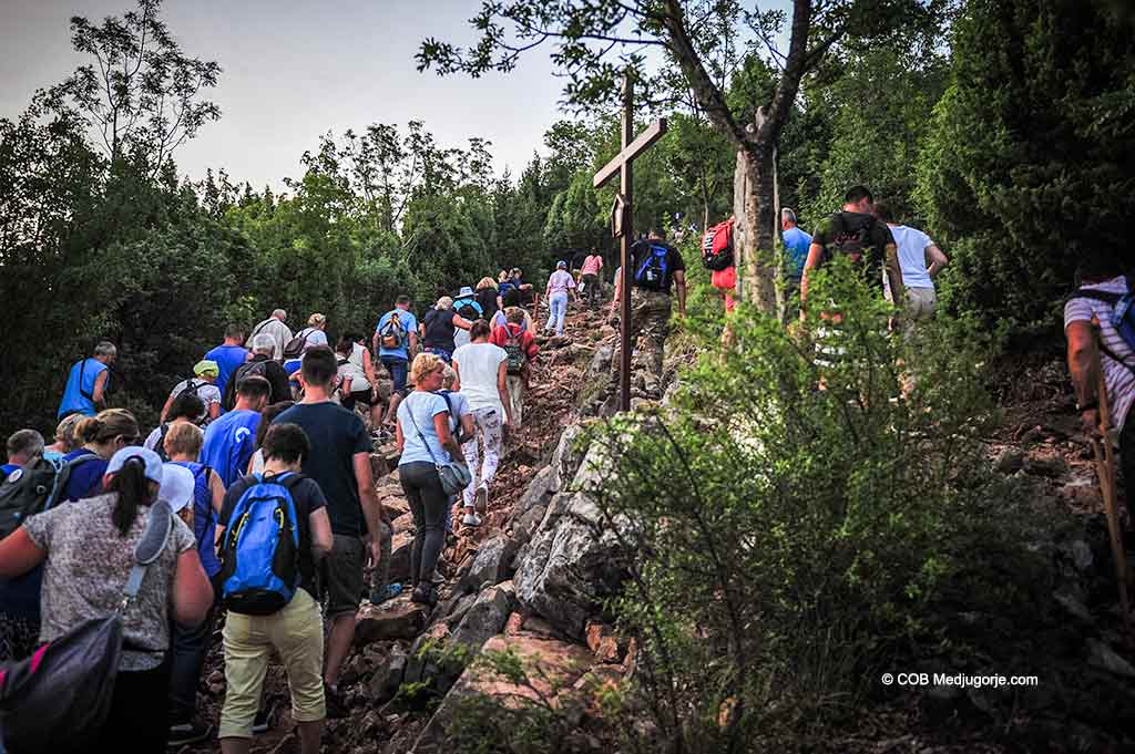 Pilgrims climbing Cross Mountain August 2019