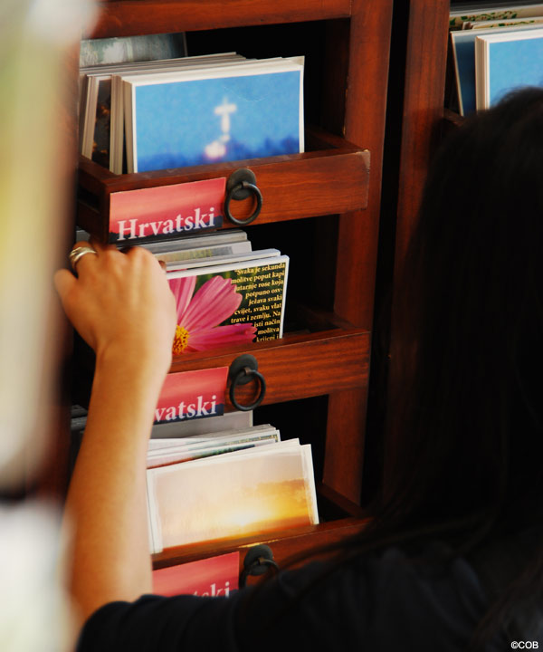 A Pilgrim looking through postcards in the Caritas Mission House
